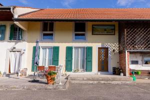 una casa con persianas verdes y una puerta principal en La Belle Ferme en Cottens