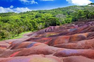 um monte de pedras vermelhas com árvores ao fundo em Day tours around Mauritius island. (North, South, East, West) em Plaine Magnien