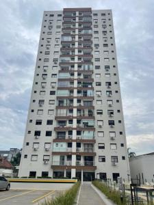 ein hohes weißes Gebäude mit vielen Fenstern in der Unterkunft Apto COND PRIVATIVO piscina, academia e garagem in Porto Alegre