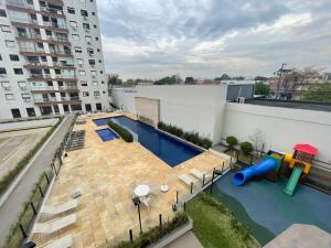 un patio de apartamentos con piscina y parque infantil en Vista Panorâmica com piscina, en Porto Alegre