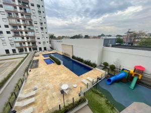 eine Apartmentterrasse mit Pool und Spielplatz in der Unterkunft Apto COND PRIVATIVO piscina, academia e garagem in Porto Alegre