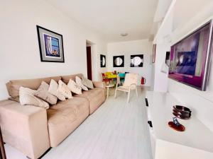 ein Wohnzimmer mit Sofa und Tisch in der Unterkunft Apto COND PRIVATIVO piscina, academia e garagem in Porto Alegre