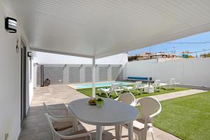 El Matorral的住宿－Casa Muley，庭院的白色遮阳伞下的桌椅