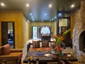 ein Wohnzimmer mit einem Tisch und einem Steinkamin in der Unterkunft Quan Din Ngai Villa in Dồng Văn