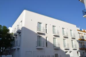 un edificio blanco con balcones en un lateral en Hotel OASIS CENTRO en Conil de la Frontera