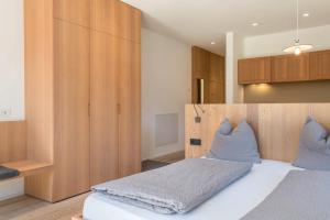 um quarto com uma cama grande e uma cabeceira em madeira em Vista Dolomites Apartment Liberty em Santa Cristina in Val Gardena
