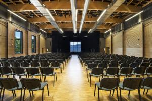 an empty hall with rows of chairs in it at L'ESCANDILLE Village Vacances in Autrans +24 photos