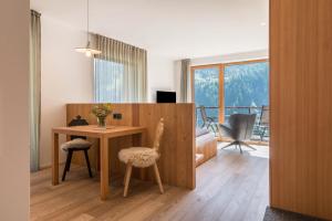 Habitación con mesa, 2 sillas y escritorio. en Vista Dolomites Apartment Liberty en Santa Cristina in Val Gardena