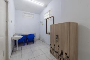 a bathroom with a sink and blue chairs in it at Urbanview Hotel D'Pineapple Villa Ciater in Subang