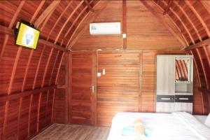 um quarto com uma cama num quarto de madeira em Sekar Kuning Cottage em Toyapakeh