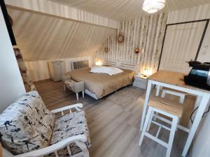 ein Schlafzimmer mit einem Bett, einem Sofa und einem Tisch in der Unterkunft Au Ch'ti Suisse 