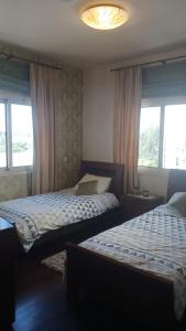 2 camas en una habitación con 2 ventanas en Quattro Sea View Beachfront Ap 6, en Lárnaca
