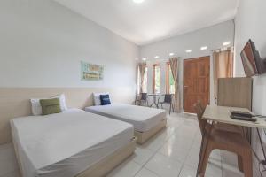 a hotel room with two beds and a table at Urbanview Hotel D'Pineapple Villa Ciater in Subang