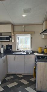 uma pequena cozinha com um lavatório e uma janela em Ashdale By Sea em Whitstable