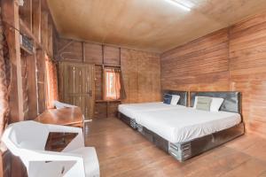 a bedroom with a bed and wooden walls at Urbanview Hotel D'Pineapple Villa Ciater in Subang