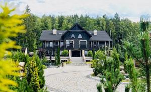 a large black house with trees in the background at Dolina Wikingów-apartament typu Suite Deluxe z 16 m tarasem w ogrodzie, miejscem w garażu i dostępem do strefy Wellness in Szklarska Poręba