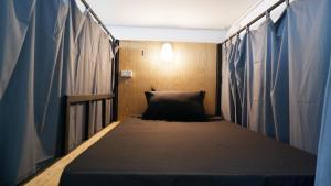 un letto in una stanza con un cuscino sopra di DonMueang station hostel a Ban Don Muang (1)