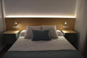 a bedroom with a bed with two night stands at Hotel OASIS CENTRO in Conil de la Frontera