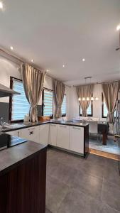 cocina con armarios blancos y comedor en Ismar Residence, en Sarajevo