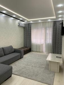 ein Wohnzimmer mit einem Sofa und einem Tisch in der Unterkunft Кылышбай акына in Taras