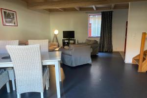 ein Wohnzimmer mit einem Tisch, Stühlen und einem Sofa in der Unterkunft Himmel & Hölle Ferienhäuser in Quedlinburg