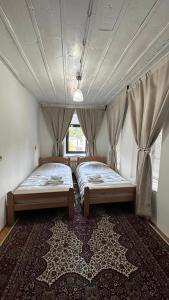 2 camas en una habitación con ventana en Ismar Residence, en Sarajevo