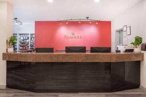 a bar in a store with a red wall at Ramada by Wyndham Bakersfield in Bakersfield