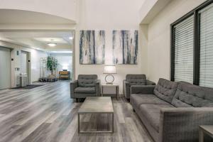 a living room with two couches and a table at Ramada by Wyndham Bakersfield in Bakersfield