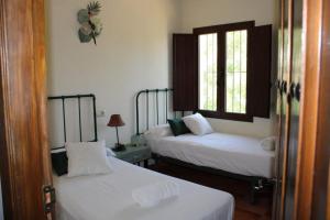 duas camas num quarto com duas janelas em Complejo Cortijo Rural el Puntal em Teba