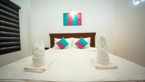 a bedroom with a bed with two white towels on it at JAMUNA VILLA in Jaffna