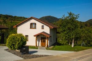 Casa blanca con puerta marrón y árboles en Шаян Гора, en Shayan