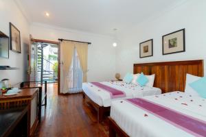 ein Hotelzimmer mit 2 Betten und einem Schreibtisch in der Unterkunft Asanak D'Angkor Boutique Hotel in Siem Reap