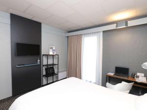 a hotel room with a bed and a television at ibis Egletons in Égletons