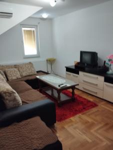 a living room with a couch and a coffee table at Apartman Šljivo in Konjic