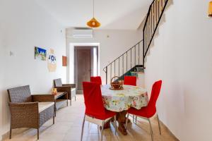 una sala da pranzo con tavolo e sedie rosse di Casa vacanze Ghilarza Sardegna a Ghilarza