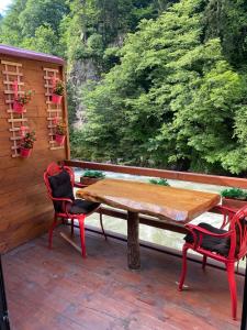 una mesa de madera y 2 sillas en el porche en Hoşdere Suit, en Çamlıhemşin