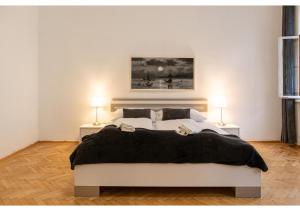 1 dormitorio con 1 cama blanca grande y 2 lámparas en Deluxe 3BR Apt. Wiener Stadthalle - Suitable for Longstays, en Viena