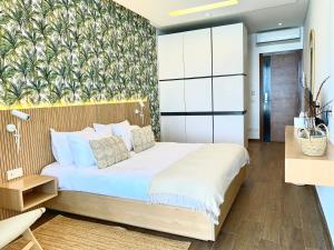 een slaapkamer met een groot bed met een muur bij Majestic Palm Beachfront Exotic Room in Batroun 