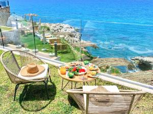 a table with a plate of food on top of the ocean at Majestic Palm Beachfront Exotic Room in Batroun 