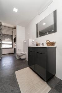 y baño con lavabo, aseo y espejo. en Luxury Harav Agan 3 Bd apt, en Jerusalén