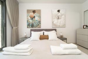 1 dormitorio con 1 cama grande y 2 cuadros en la pared en Luxury Harav Agan 3 Bd apt, en Jerusalén