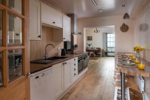 a kitchen with white cabinets and a wooden floor at Central Llanrwst apartment ~ Perfect for walkers and MTB riders in Llanrwst