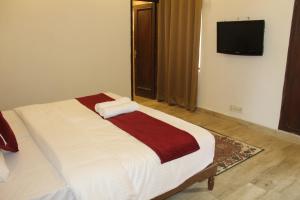 ein Schlafzimmer mit einem Bett und einem TV an der Wand in der Unterkunft Khanna Residency in Neu-Delhi