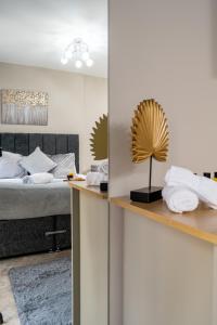 a bedroom with a bed and a shelf with towels at Willow Lodge Apartment in Solihull