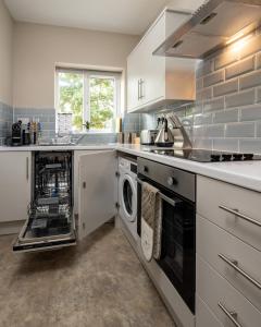 a kitchen with a washer and dryer at Modern studio apartment - Close to the NEC, Airport, and Solihull Town - Parking in Solihull +5 photos