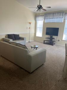 een woonkamer met een bank en een flatscreen-tv bij Luxury Apartment near Disney and other Theme parks in Kissimmee