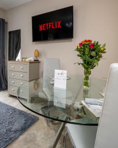 a glass table with a vase of flowers on a wall at Willow Lodge Apartment in Solihull