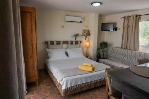 a bedroom with a bed and a couch at Cozy Studio with Rooftop Terrace & Cityscape Views in Le Bardo