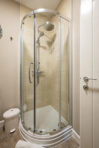 a shower stall in a bathroom with a toilet at Willow Lodge Apartment in Solihull