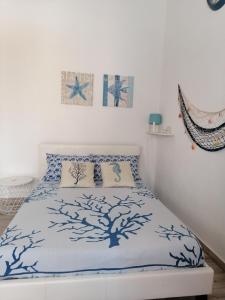 a bedroom with a bed with a blue and white bedspread at Blue Cottage monolocale centro Sciacca in Sciacca